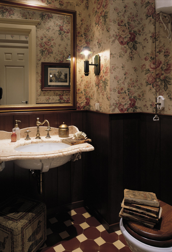 Example of an ornate ceramic tile powder room design in Moscow with a console sink and marble countertops