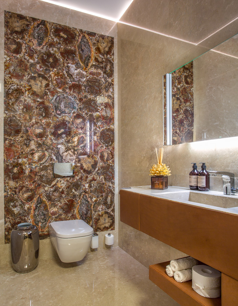 Idee per un piccolo bagno di servizio minimal con WC sospeso, piastrelle di marmo, pavimento in marmo, pavimento beige, ante lisce, piastrelle beige, piastrelle marroni, lavabo integrato e pareti beige