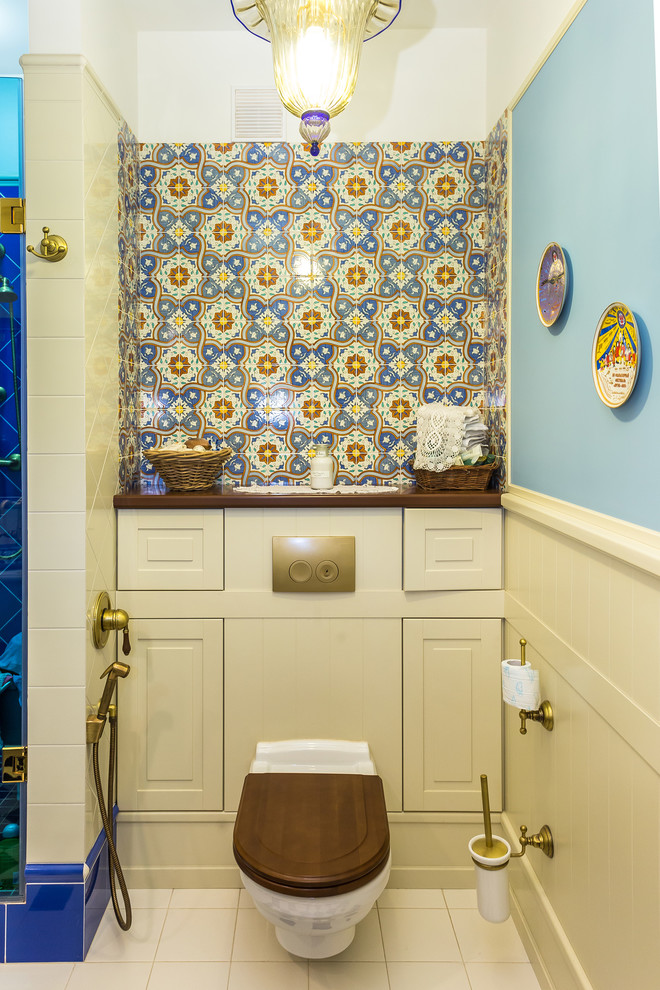 Esempio di un bagno di servizio eclettico con WC sospeso, pareti blu e pavimento beige