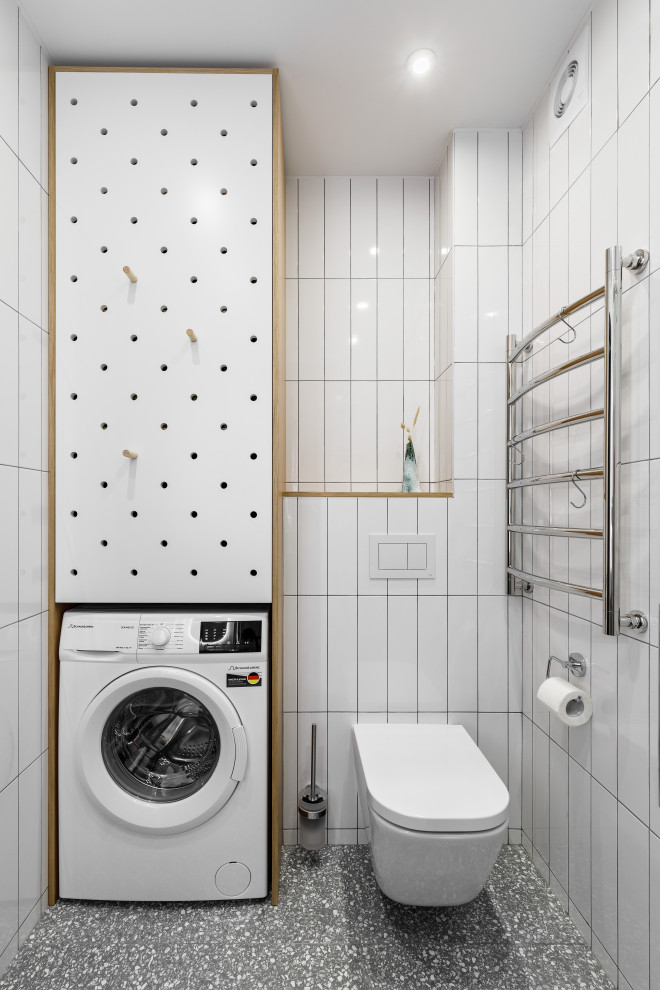 Foto på ett minimalistiskt toalett, med en vägghängd toalettstol och grått golv
