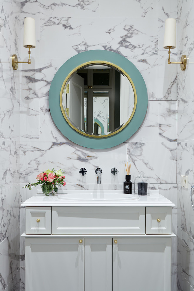 Powder room - transitional powder room idea in Moscow with recessed-panel cabinets, white cabinets, a drop-in sink and white countertops