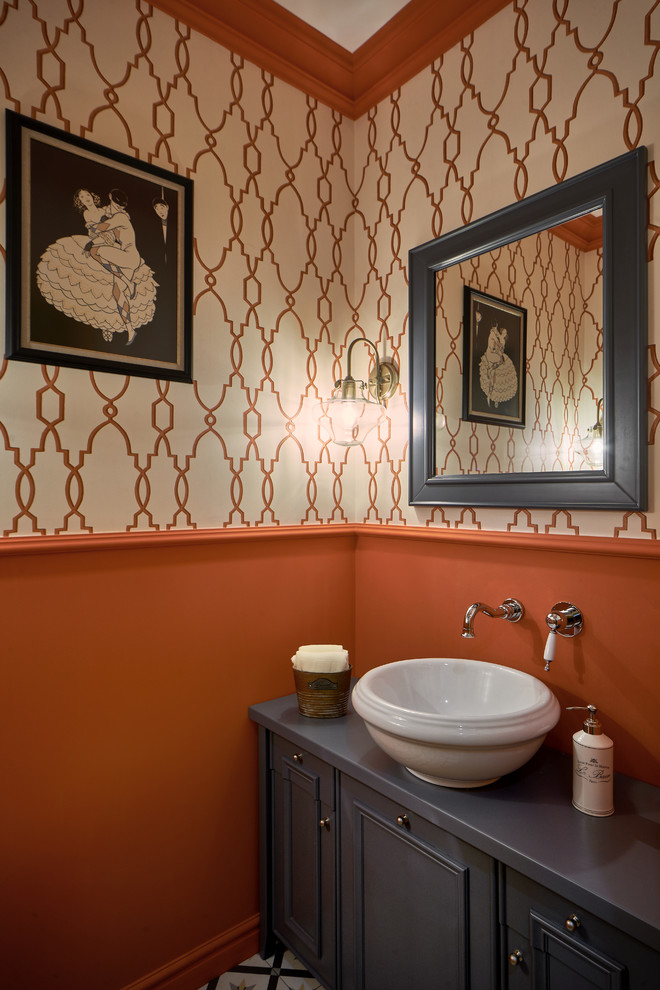 Réalisation d'un WC et toilettes tradition avec un placard avec porte à panneau encastré, des portes de placard grises, une vasque et un mur orange.