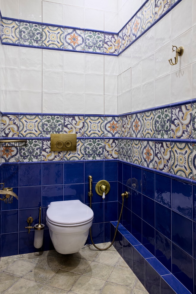 Imagen de aseo mediterráneo con sanitario de pared, baldosas y/o azulejos azules, baldosas y/o azulejos blancos y baldosas y/o azulejos multicolor