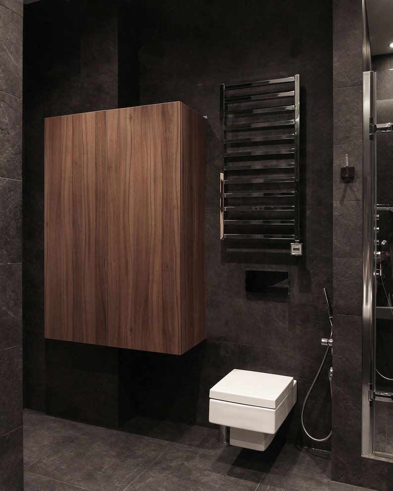 Immagine di un piccolo bagno di servizio minimal con WC sospeso, piastrelle nere, piastrelle in gres porcellanato, pavimento in gres porcellanato e pavimento nero