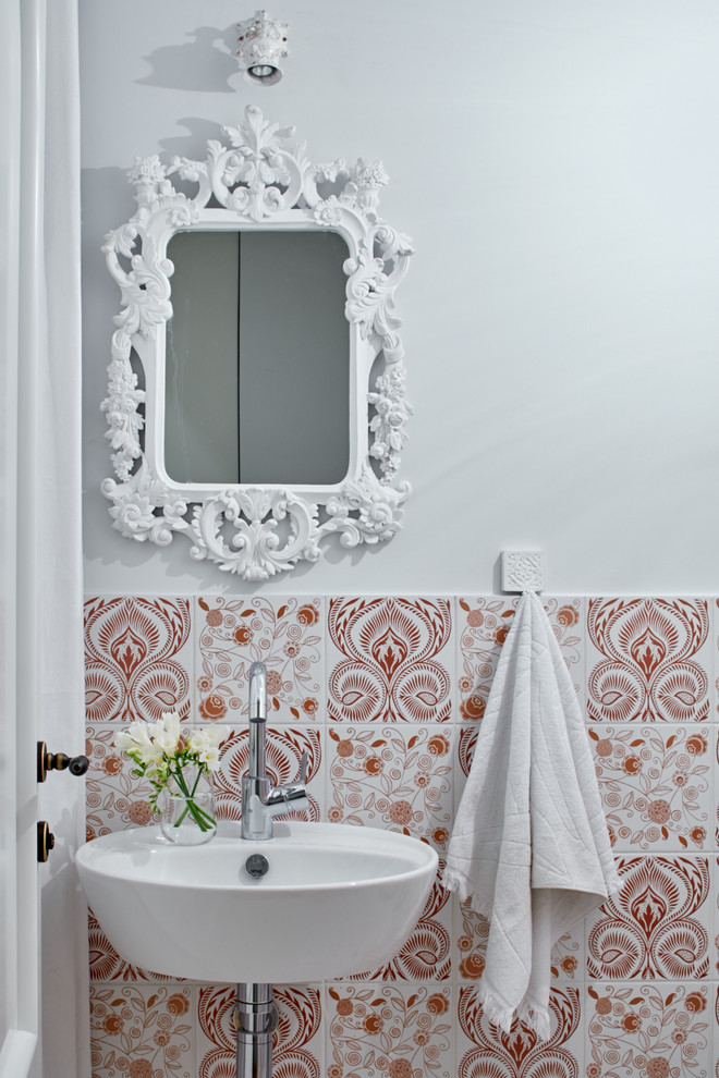 Idée de décoration pour un WC et toilettes méditerranéen avec un carrelage rose, un lavabo suspendu et un mur multicolore.