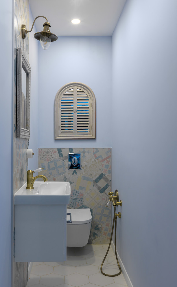 Foto di un bagno di servizio chic con ante lisce, ante bianche, WC sospeso, piastrelle multicolore, piastrelle in gres porcellanato, pareti blu, pavimento in gres porcellanato, lavabo integrato e pavimento grigio