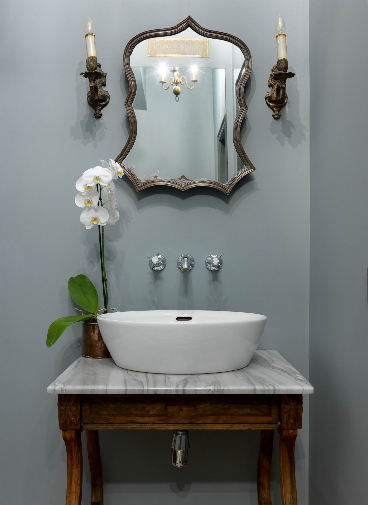 Foto di un bagno di servizio tradizionale con consolle stile comò, ante in legno bruno, pareti grigie, lavabo a bacinella e top bianco