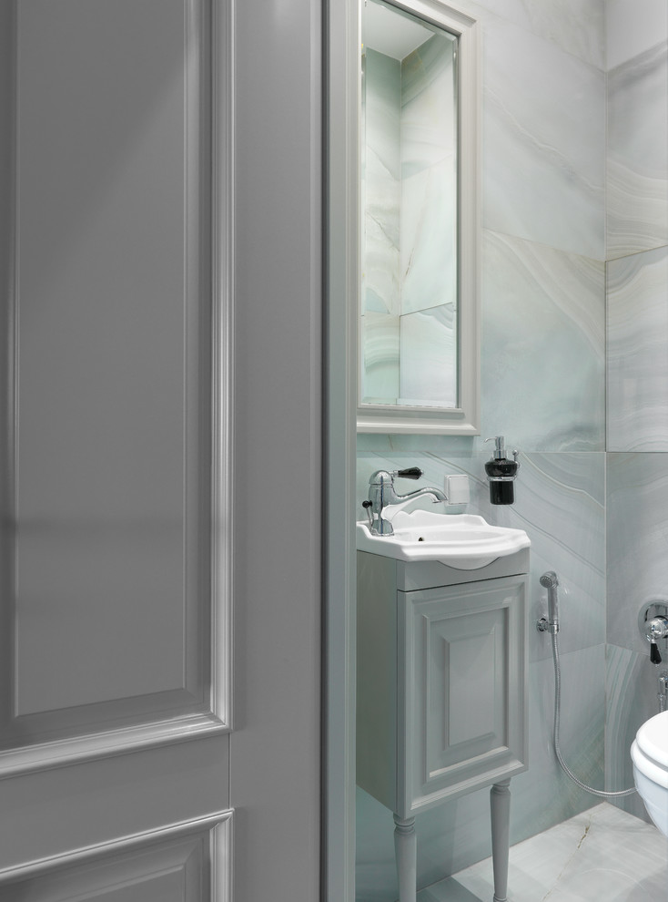 На фото: туалет в стиле неоклассика (современная классика) с фасадами с выступающей филенкой, серыми фасадами, серой плиткой, серым полом, серыми стенами и консольной раковиной с