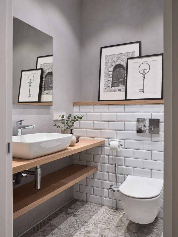 Réalisation d'un petit WC et toilettes design avec des portes de placard beiges, un carrelage blanc, un mur gris, un plan de toilette beige et meuble-lavabo suspendu.