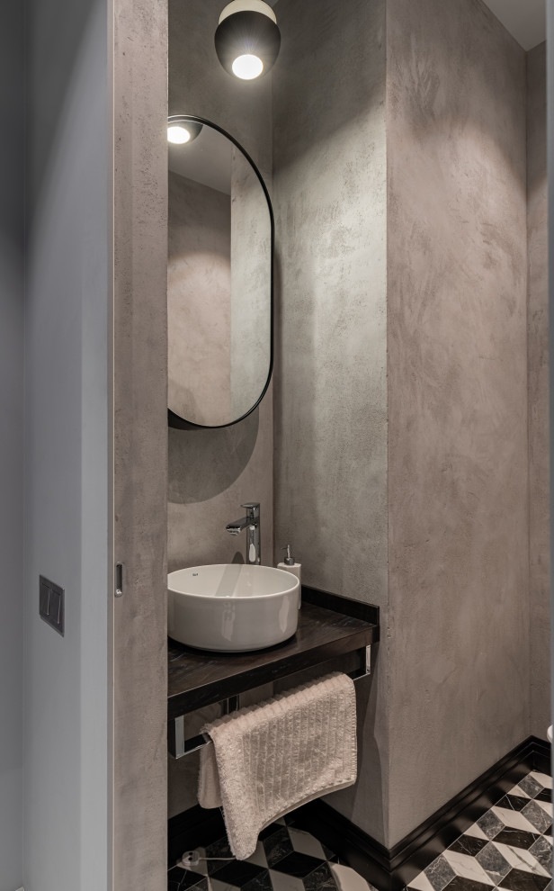 На фото: туалет среднего размера в современном стиле с открытыми фасадами, серой плиткой, полом из мозаичной плитки, настольной раковиной, серым полом и черной столешницей с