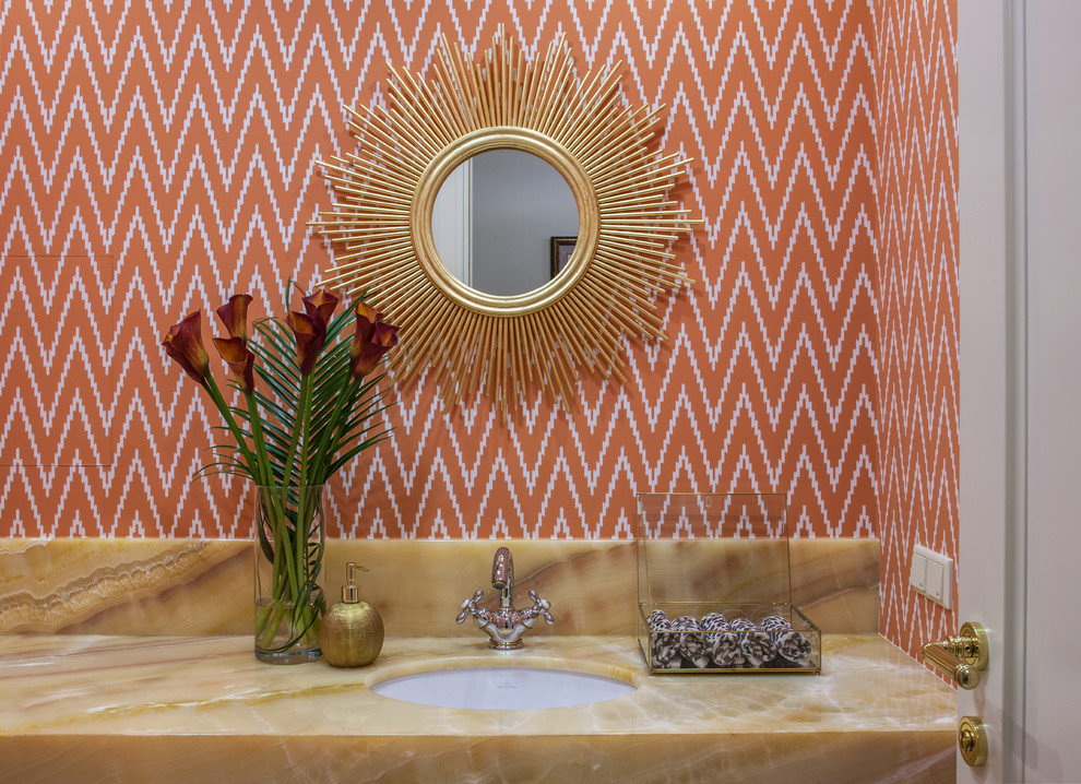 モスクワにあるトランジショナルスタイルのおしゃれなトイレ・洗面所 (オレンジの壁、アンダーカウンター洗面器、オニキスの洗面台) の写真