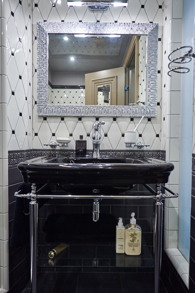 На фото: туалет в стиле неоклассика (современная классика) с консольной раковиной, белой плиткой, черно-белой плиткой и черной плиткой