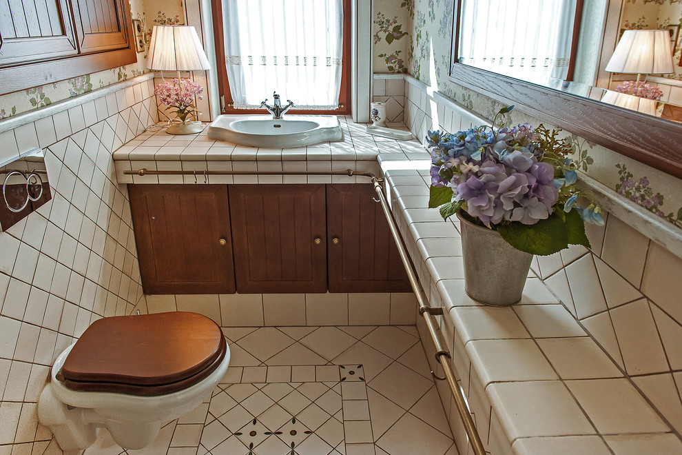 Idée de décoration pour un WC suspendu champêtre avec des carreaux de porcelaine, un sol en carrelage de porcelaine, un lavabo posé, un plan de toilette en carrelage et un carrelage blanc.