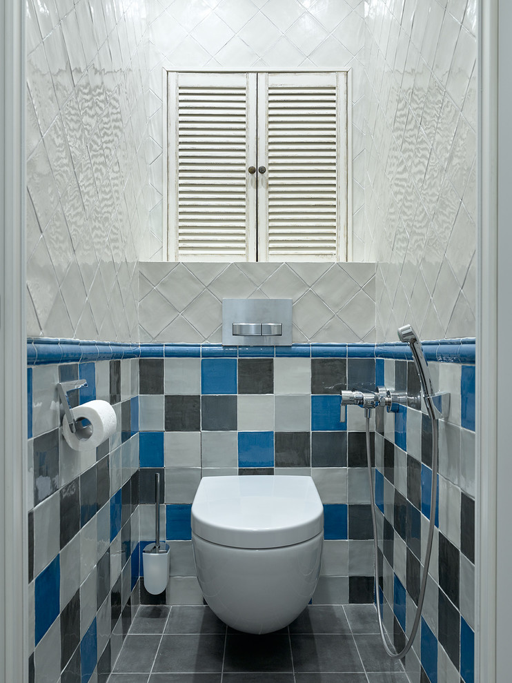 На фото: туалет в современном стиле с инсталляцией, синей плиткой, белой плиткой, серой плиткой и серым полом с