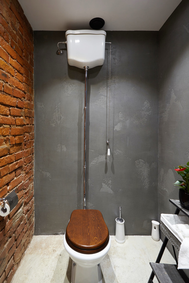 Inspiration för ett mellanstort industriellt toalett, med en toalettstol med separat cisternkåpa, grå kakel, cementkakel, röda väggar, betonggolv, ett piedestal handfat och grått golv