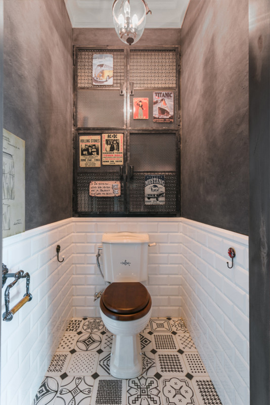 Foto di un bagno di servizio industriale di medie dimensioni con piastrelle bianche, pavimento in gres porcellanato, WC a due pezzi, piastrelle diamantate e pareti nere