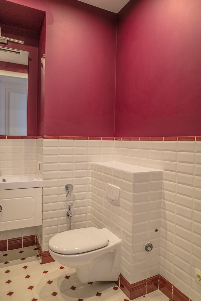 Идея дизайна: большой туалет в современном стиле с белыми фасадами, инсталляцией, белой плиткой, плиткой кабанчик, розовыми стенами и монолитной раковиной