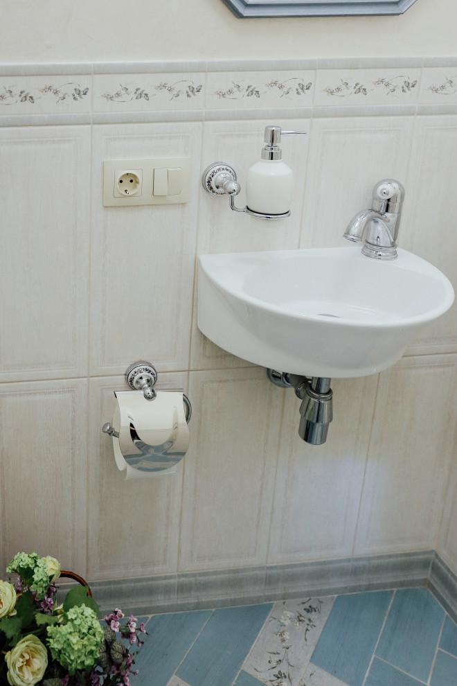 Inspiration för små klassiska toaletter, med en vägghängd toalettstol, beige kakel, keramikplattor, beige väggar, klinkergolv i porslin, ett väggmonterat handfat och turkost golv