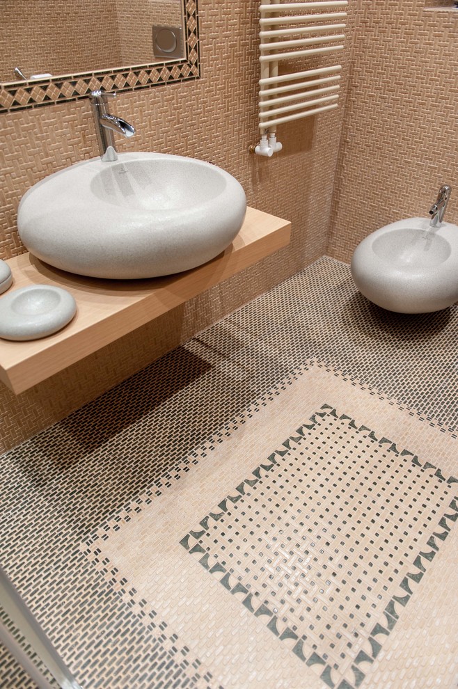 モスクワにある地中海スタイルのおしゃれなトイレ・洗面所 (壁掛け式トイレ、ベージュのタイル、ベッセル式洗面器、マルチカラーの床) の写真