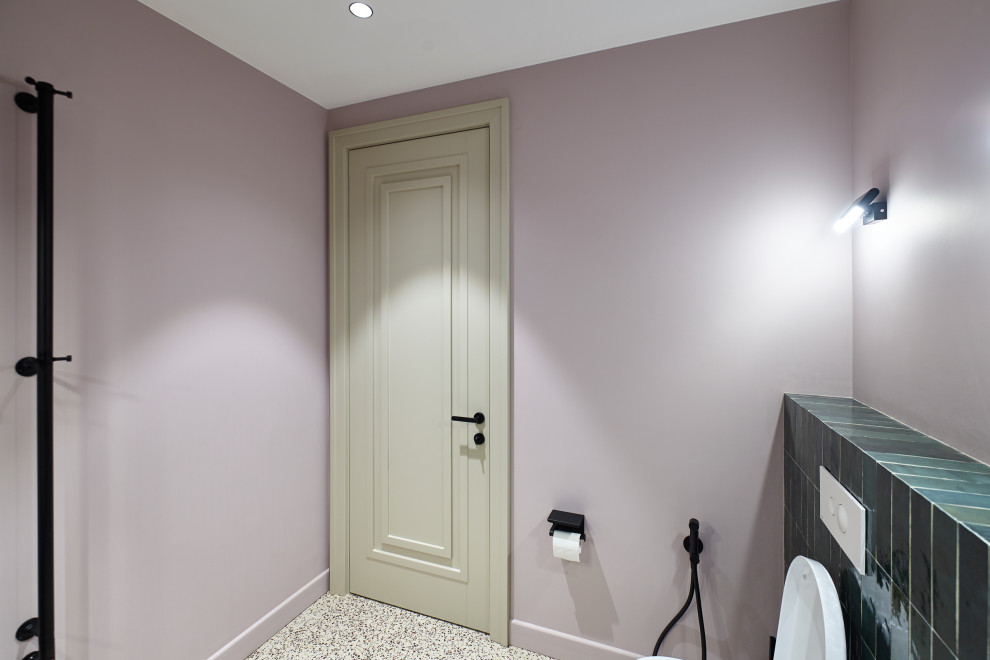 Modern inredning av ett mellanstort toalett, med vita väggar, laminatgolv och beiget golv