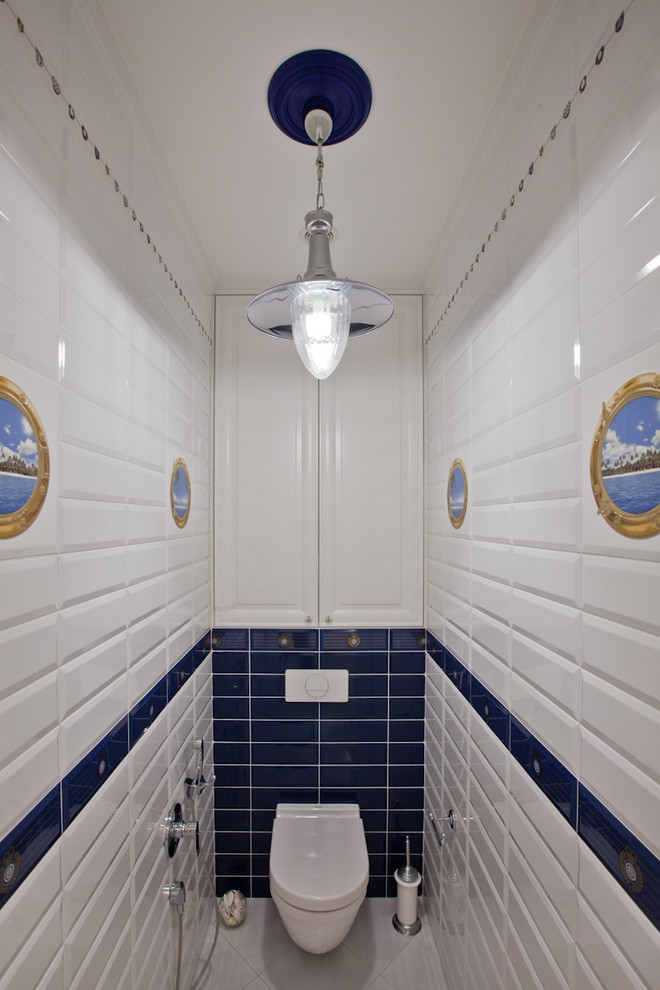 Ispirazione per un piccolo bagno di servizio stile marinaro con WC sospeso, piastrelle blu, piastrelle bianche, piastrelle in ceramica, pavimento con piastrelle in ceramica e pavimento bianco