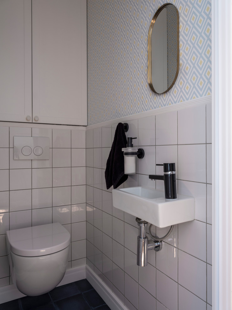 Moderne Gästetoilette mit Wandtoilette, weißen Fliesen, bunten Wänden und Wandwaschbecken in Moskau