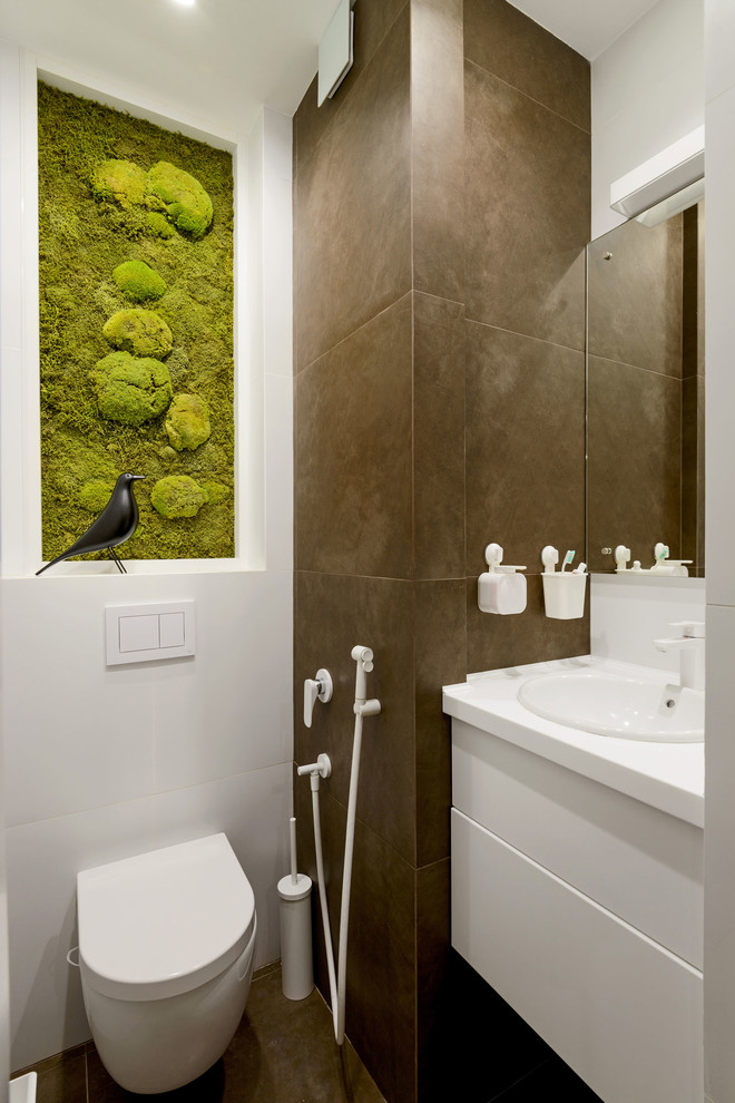 Ispirazione per un piccolo bagno di servizio design con ante lisce, ante bianche, WC sospeso, piastrelle bianche, piastrelle marroni, lavabo da incasso e pavimento marrone