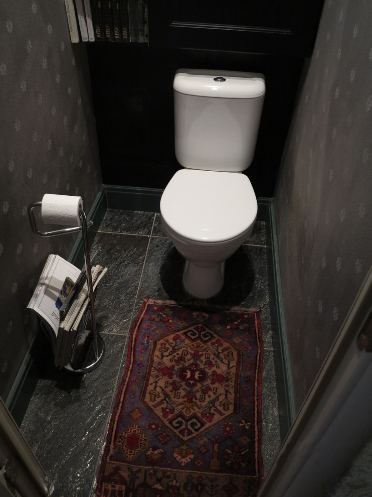 Inspiration pour un petit WC et toilettes traditionnel avec un placard avec porte à panneau surélevé, des portes de placard noires, WC à poser, un mur noir, un sol en carrelage de porcelaine et un sol noir.