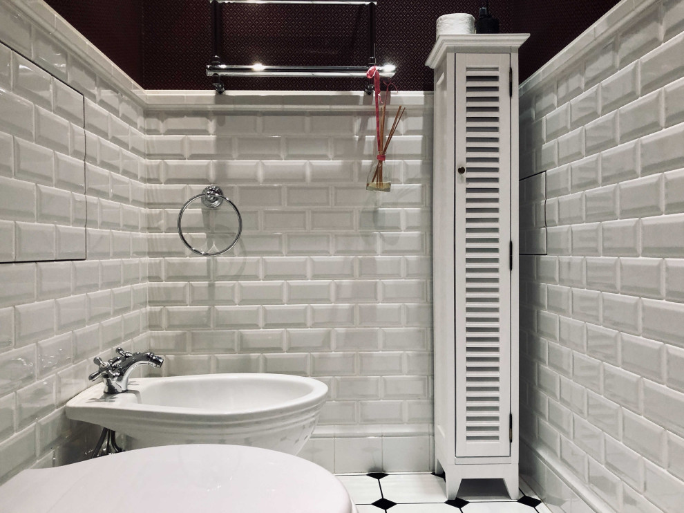 Стильный дизайн: большой туалет в стиле неоклассика (современная классика) с фасадами с утопленной филенкой, белыми фасадами, белой плиткой, керамической плиткой, зелеными стенами, полом из керамогранита, подвесной раковиной, белым полом и раздельным унитазом - последний тренд