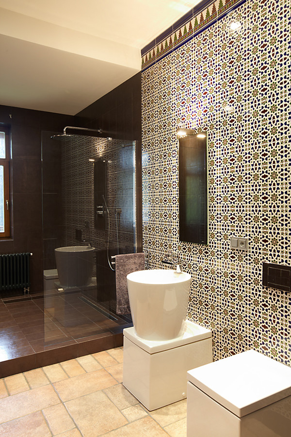 Immagine di un grande bagno di servizio eclettico con WC monopezzo, piastrelle in gres porcellanato, pavimento in gres porcellanato, lavabo a colonna, piastrelle multicolore e pavimento marrone