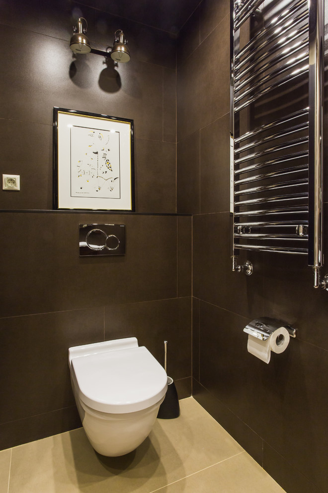 Klassisk inredning av ett toalett, med en vägghängd toalettstol och brun kakel
