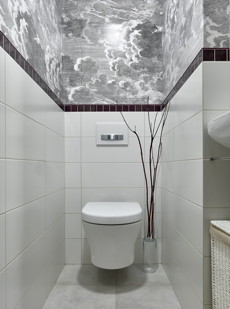 Kleine Klassische Gästetoilette mit weißen Schränken, Wandtoilette, Porzellan-Bodenfliesen, Wandwaschbecken, grauem Boden und weißer Waschtischplatte in Moskau