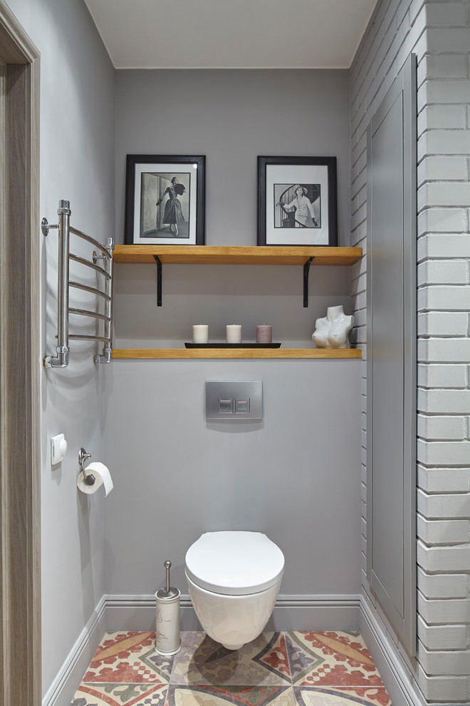 Idee per un bagno di servizio tradizionale con WC sospeso, pareti grigie e pavimento multicolore