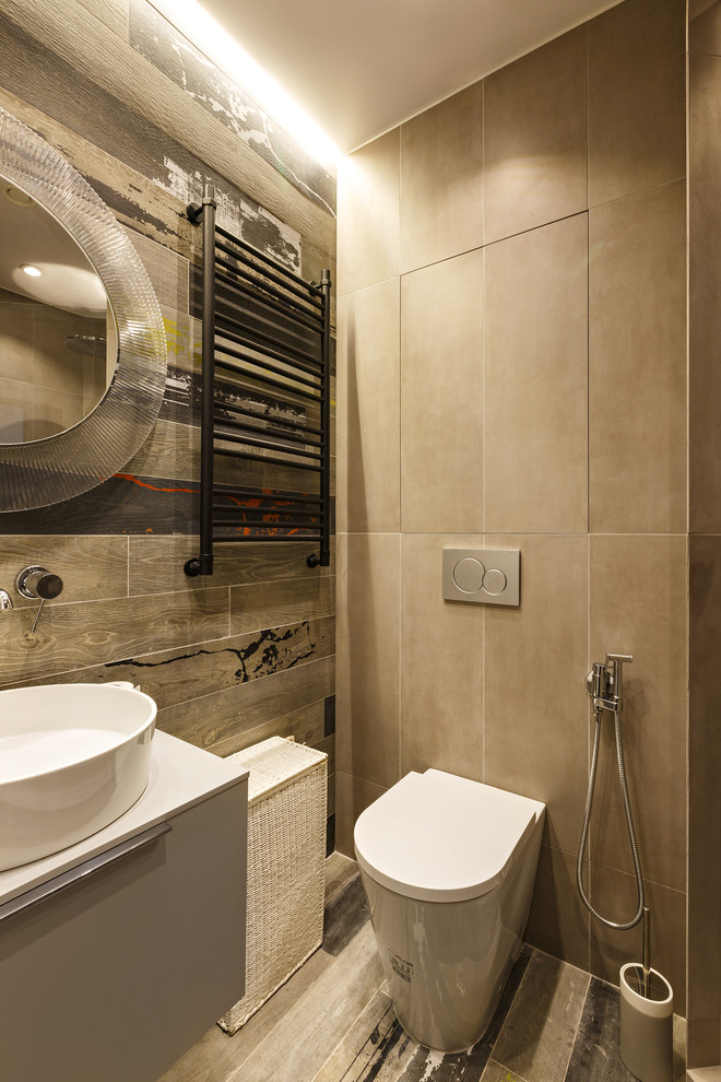 На фото: туалет в стиле лофт с плоскими фасадами, раздельным унитазом, серыми стенами, настольной раковиной и серым полом с