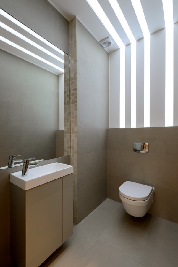 Esempio di un bagno di servizio contemporaneo con ante lisce, ante marroni, WC sospeso, piastrelle marroni e lavabo integrato