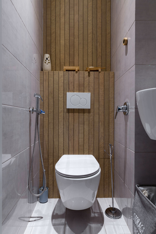 Moderne Gästetoilette mit grauen Fliesen, Keramikboden, weißem Boden und Wandtoilette in London