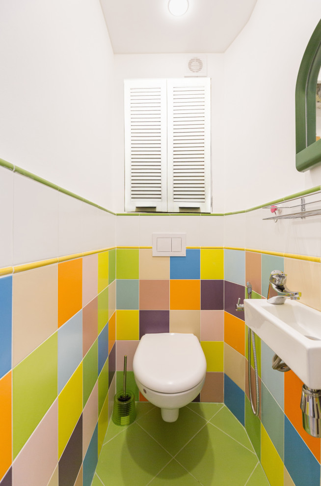 Cette image montre un petit WC suspendu design avec un carrelage multicolore, des carreaux de céramique, un sol en carrelage de céramique, un lavabo suspendu, un sol vert et un mur blanc.