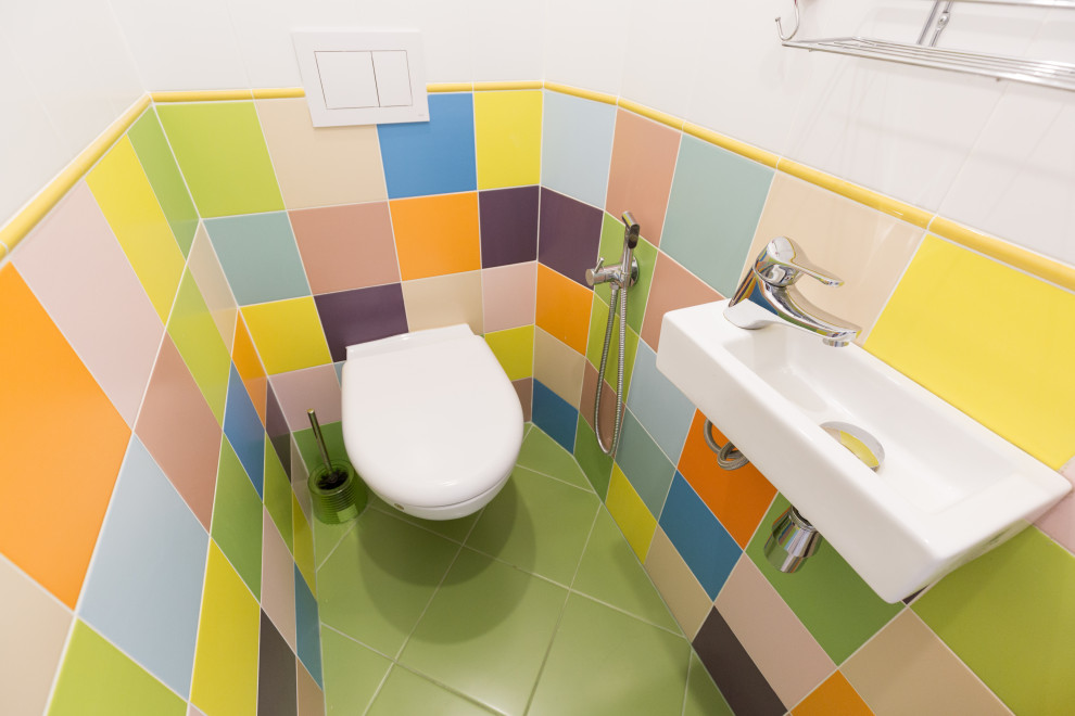 Immagine di un piccolo bagno di servizio con WC sospeso, piastrelle multicolore, piastrelle in ceramica, pareti multicolore, pavimento con piastrelle in ceramica, lavabo sospeso e pavimento verde