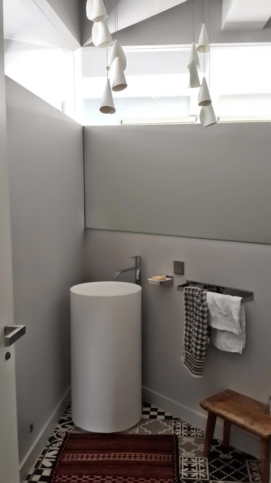 На фото: туалет в современном стиле с серыми стенами, раковиной с пьедесталом и разноцветным полом