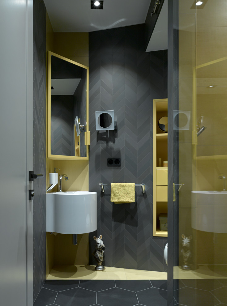 Bild på ett funkis toalett, med svart kakel, ett väggmonterat handfat, svarta väggar och svart golv