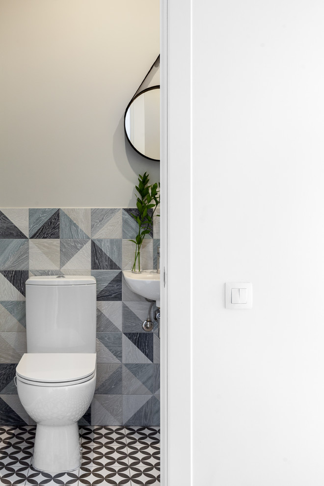Idéer för att renovera ett minimalistiskt toalett, med en toalettstol med separat cisternkåpa, blå kakel, keramikplattor, grå väggar, klinkergolv i porslin och ett väggmonterat handfat