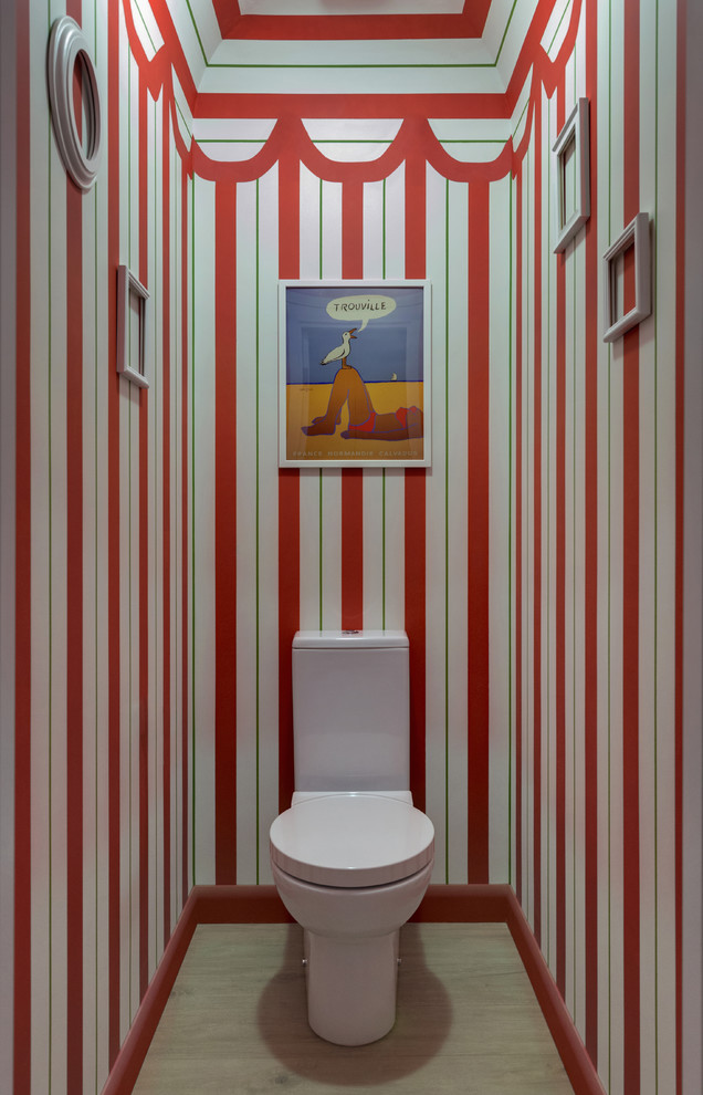На фото: туалет в современном стиле с бежевым полом, раздельным унитазом и красными стенами с