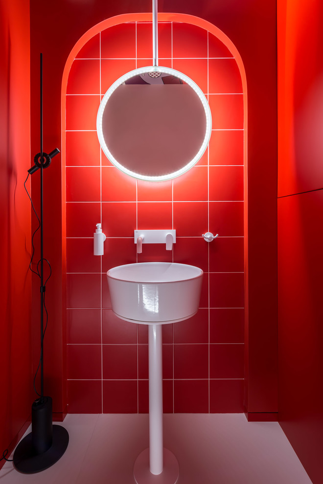 Inredning av ett modernt litet toalett, med släta luckor, röda skåp, en vägghängd toalettstol, röd kakel, keramikplattor, röda väggar, ett väggmonterat handfat och vitt golv