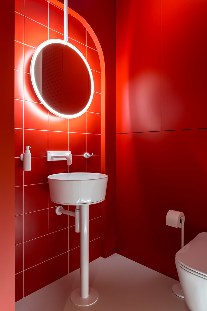 Réalisation d'un petit WC suspendu design avec un placard à porte plane, des portes de placard rouges, un carrelage rouge, des carreaux de céramique, un mur rouge, un lavabo suspendu et un sol blanc.