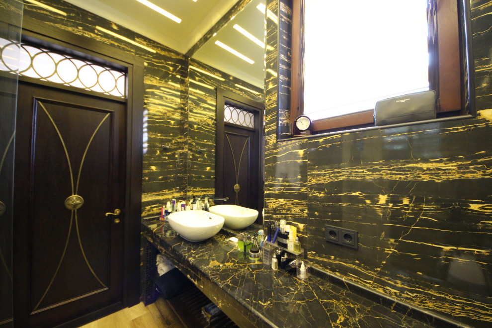 This is an example of a medium sized eclectic cloakroom in Moscow with open cabinets, white cabinets, a wall mounted toilet, black tiles, porcelain tiles, black walls, ceramic flooring, a vessel sink, marble worktops, black floors, black worktops, a floating vanity unit, a drop ceiling and panelled walls.