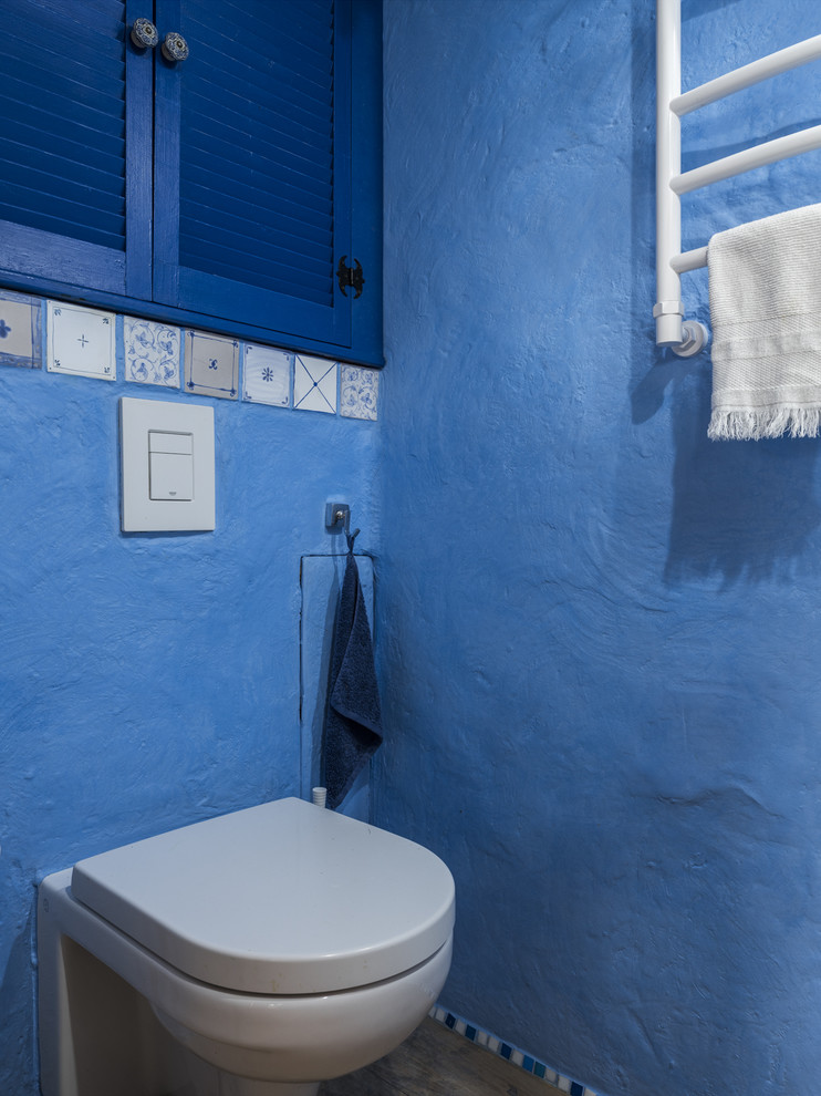 Идея дизайна: туалет в стиле рустика с настольной раковиной и синими стенами