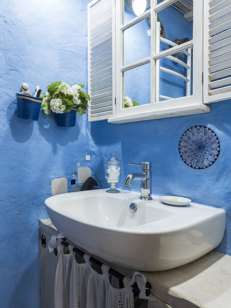 Inspiration for a rustic powder room remodel in Moscow with a vessel sink and blue walls