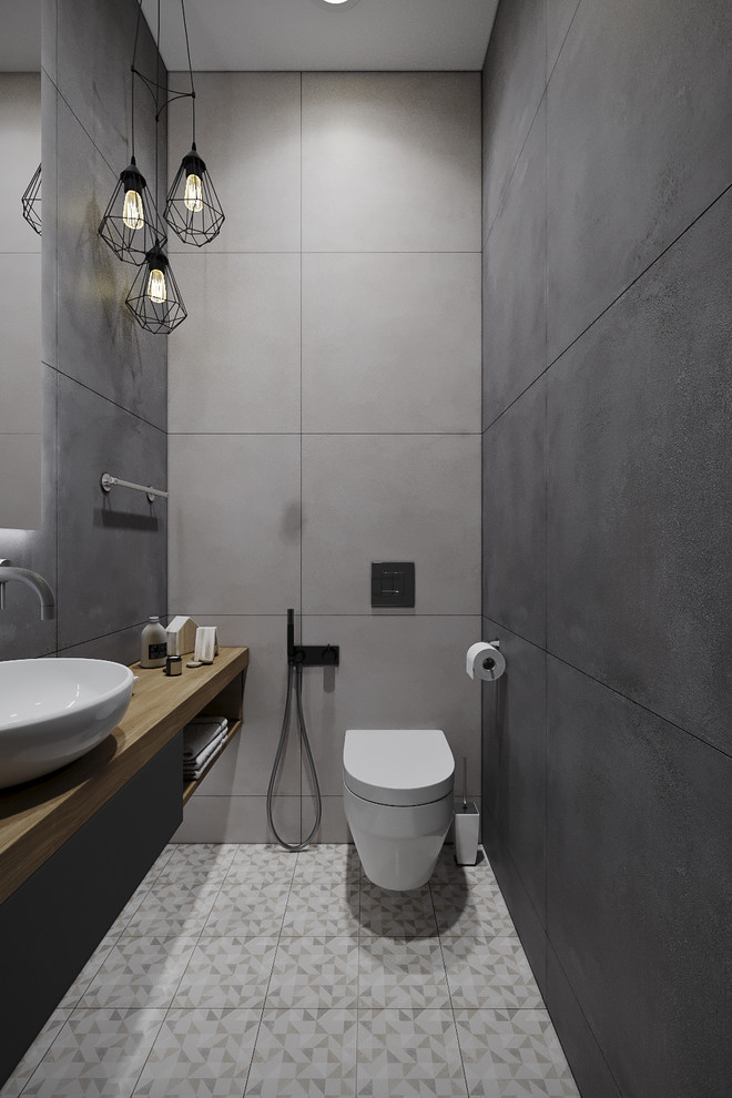 Inspiration for a small contemporary gray tile and porcelain tile porcelain tile and brown floor powder room remodel in Moscow with flat-panel cabinets, gray cabinets, a wall-mount toilet, gray walls, a vessel sink, wood countertops and brown countertops