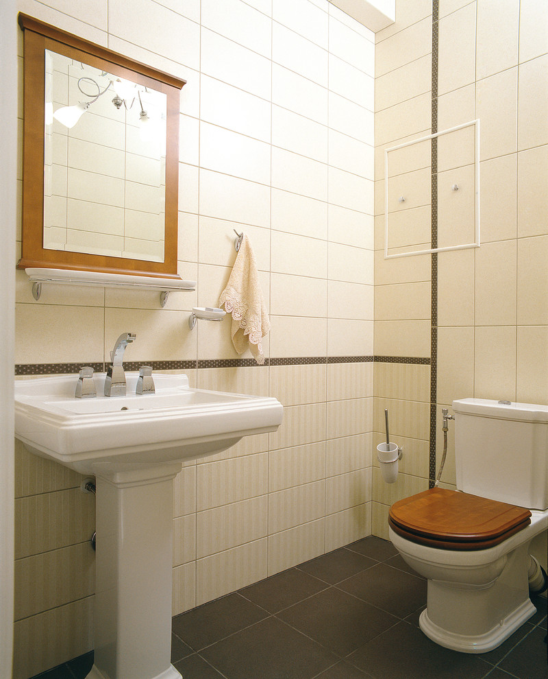 Стильный дизайн: туалет в классическом стиле с раздельным унитазом, бежевой плиткой и раковиной с пьедесталом - последний тренд