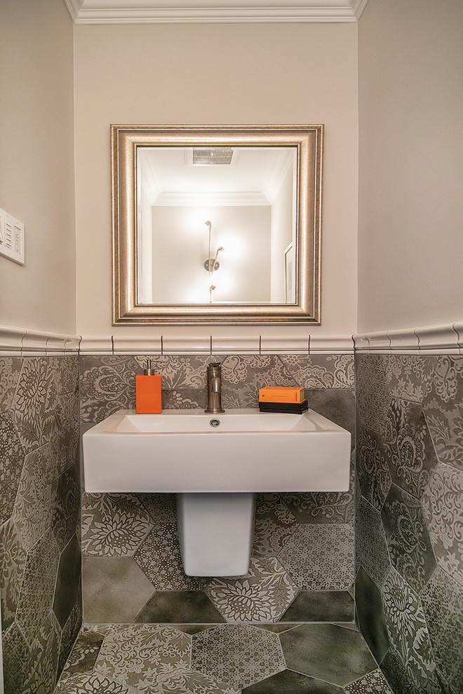 Пример оригинального дизайна: туалет в стиле неоклассика (современная классика) с серой плиткой, бежевыми стенами, подвесной раковиной и серым полом